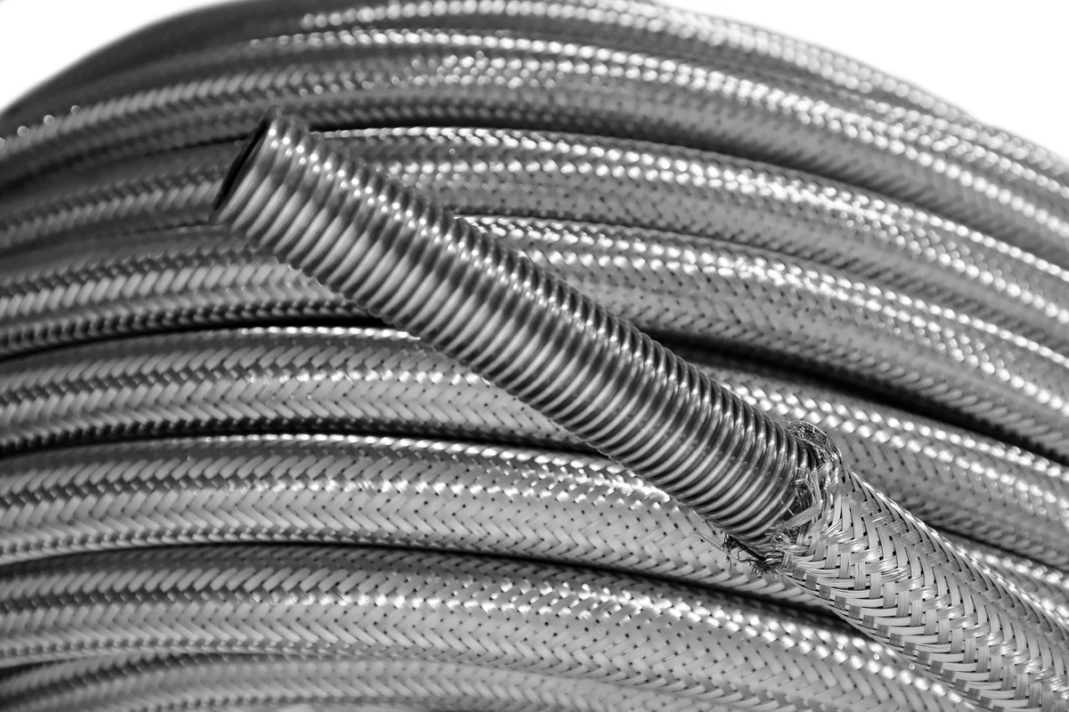 SS corrugated hose coil with braid pulled back exposing the corrugated tube